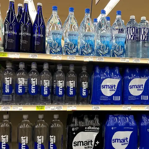 Stack of plastic water bottles bought by a Tenerife household — the costly and wasteful alternative to a home water filter