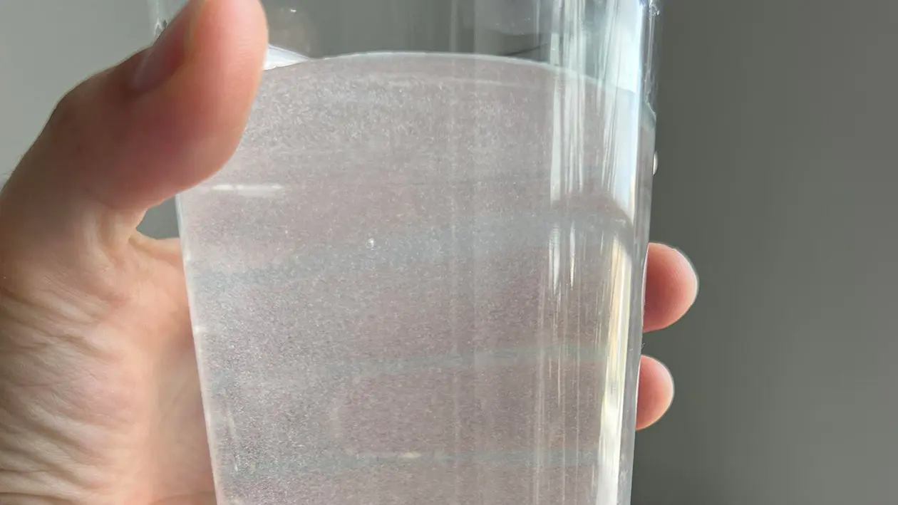Glass of Tenerife tap water showing cloudiness and white mineral residue from high limescale content